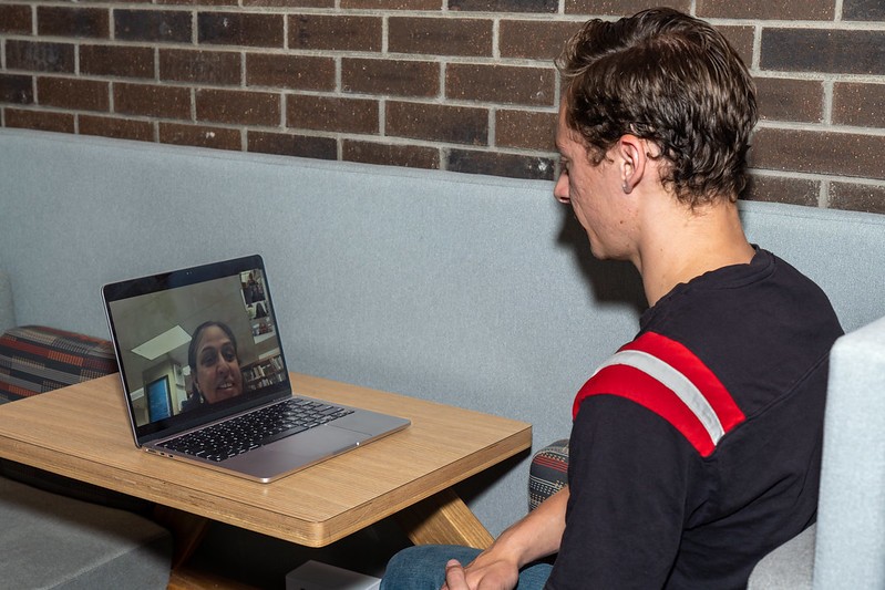 3 people sitting at a table doing homework together